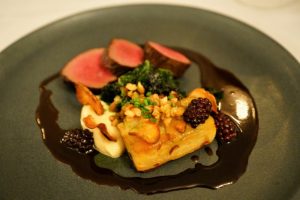 Venison loin with pickled blackberries, artichoke petals, celeriac gratin, kale, Shiraz reduction